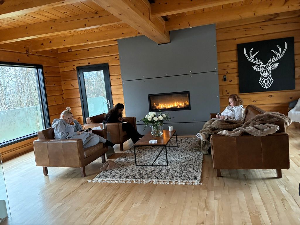 Guests relaxing by the fireplace in the cabin lounge
